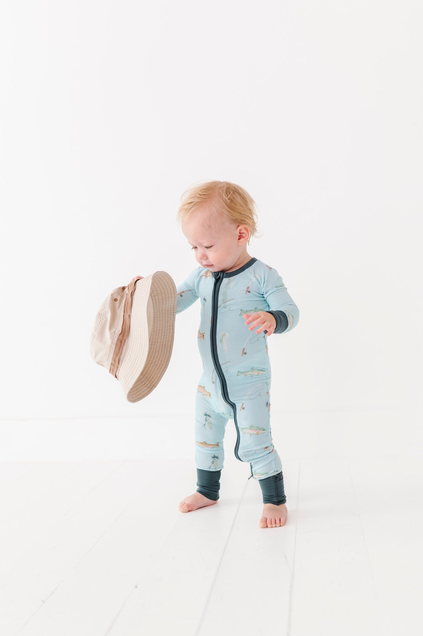 Baby in a blue onesie with a hat on a white background