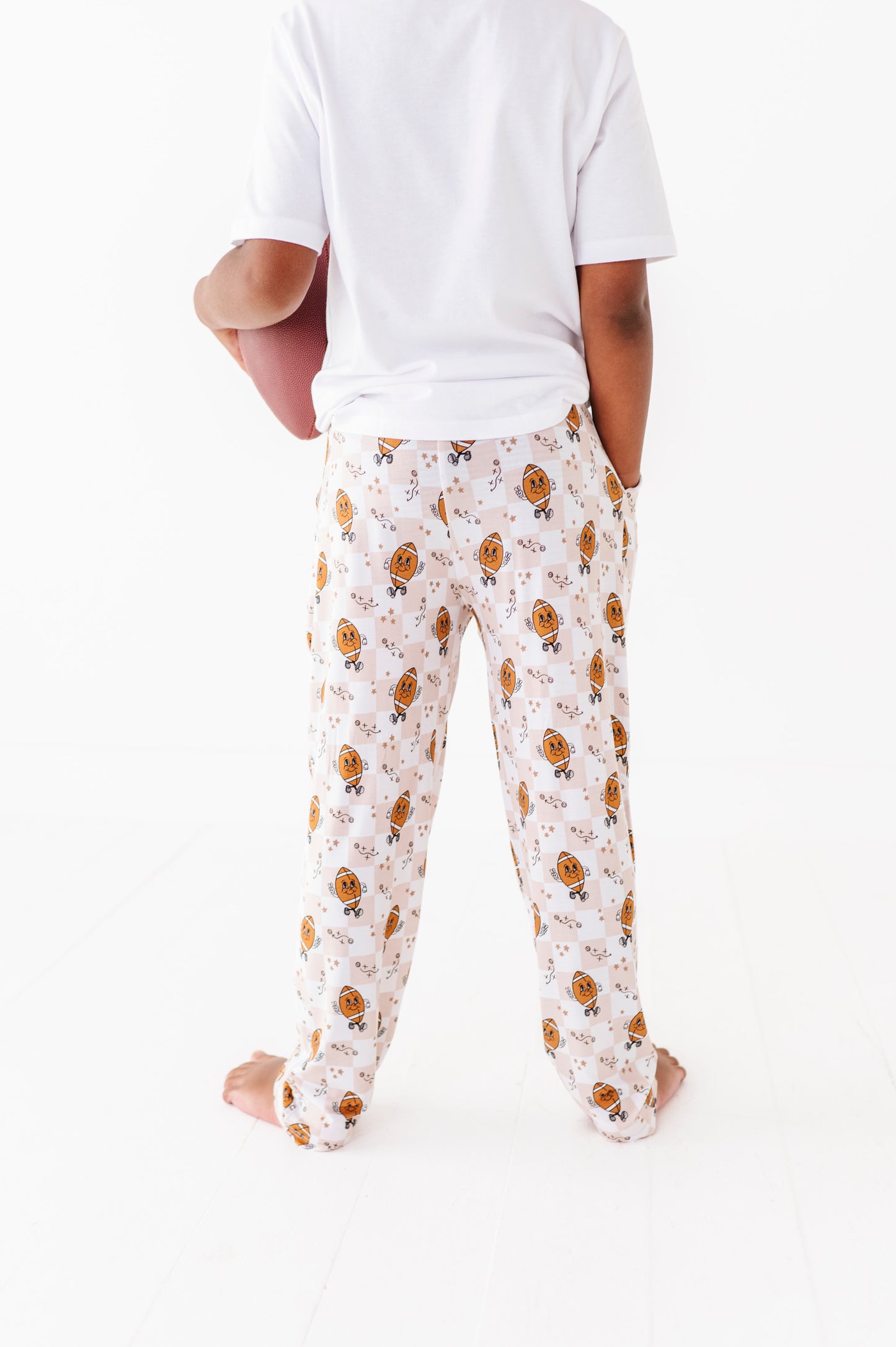 Person wearing a white t-shirt and patterned pajama pants on a white background