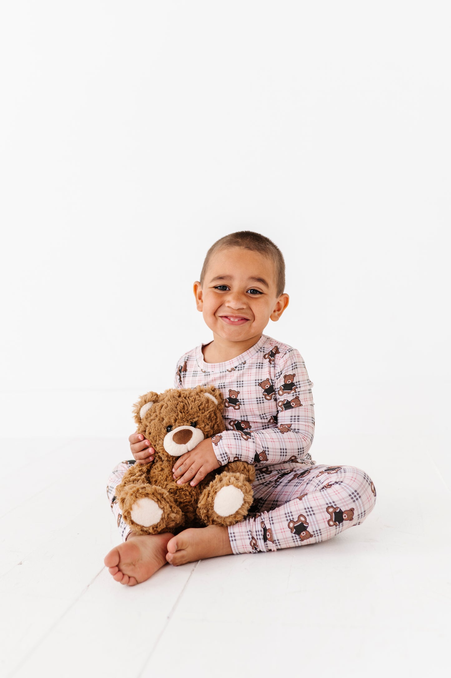 Child holding a teddy bear on a white background