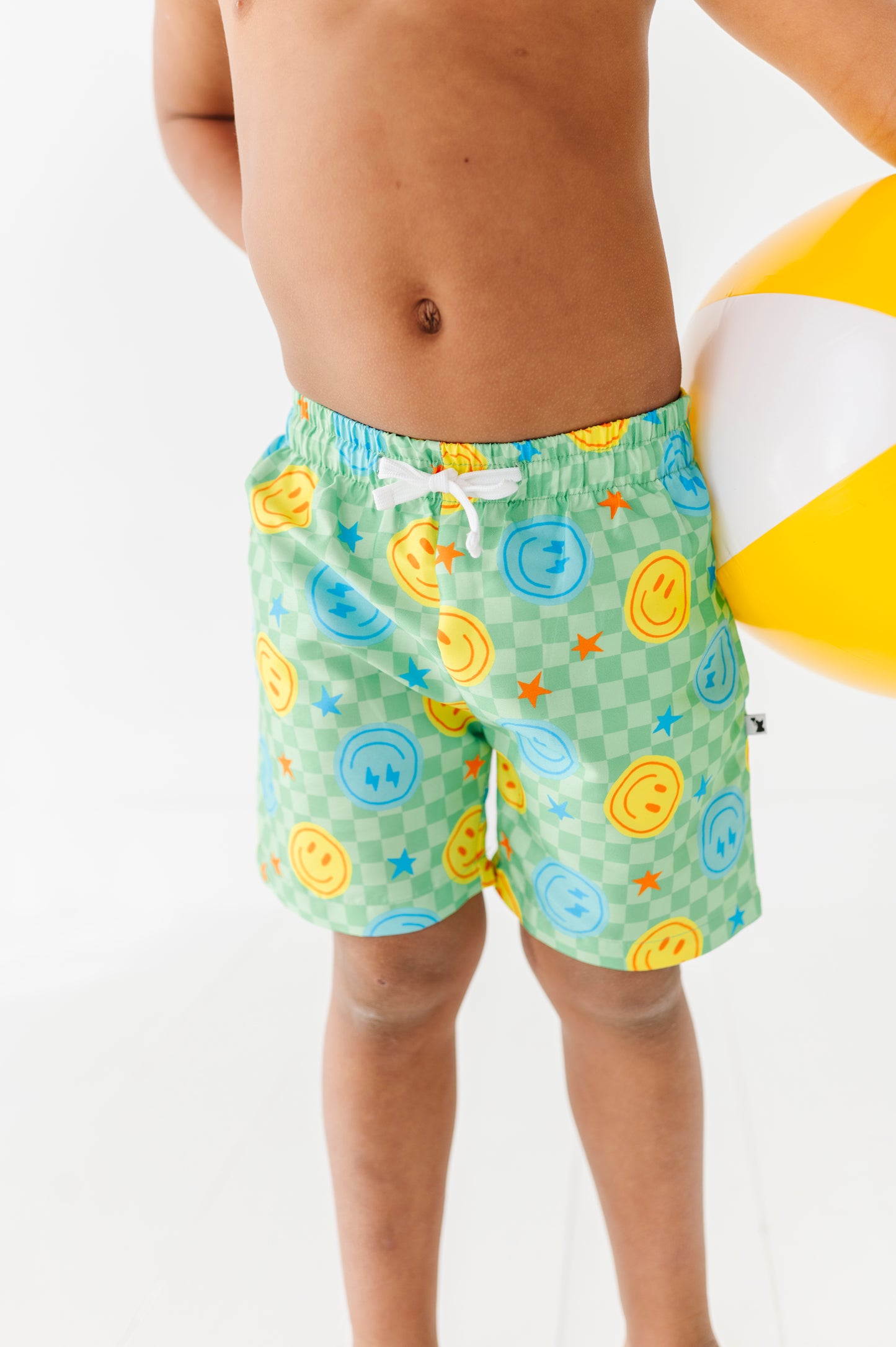 Boy rocking Neon Smiley Swim Trunks