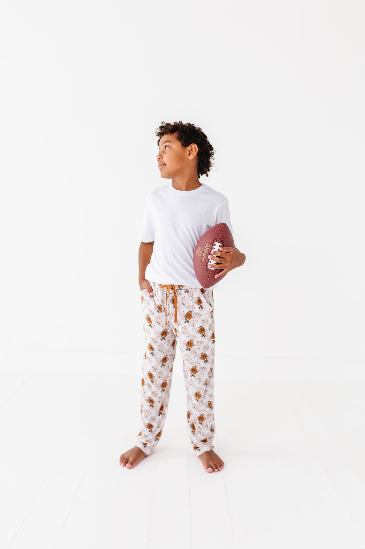 Person wearing a white t-shirt and patterned pajama pants on a white background