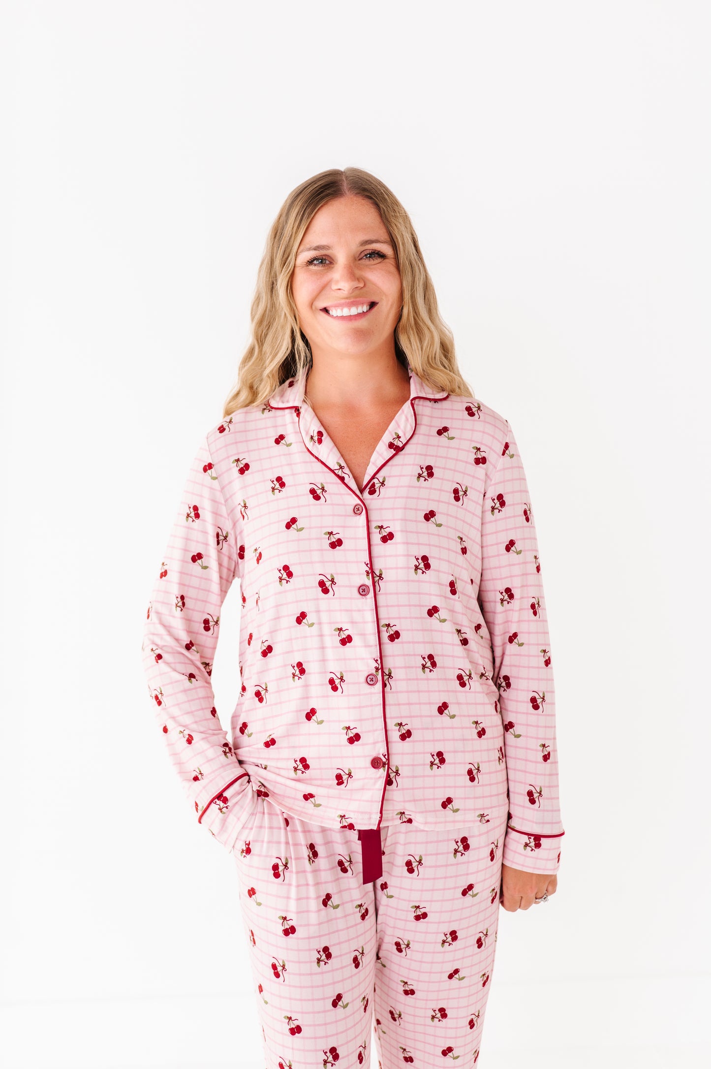 Woman wearing a pink and red patterned pajama set on a white background