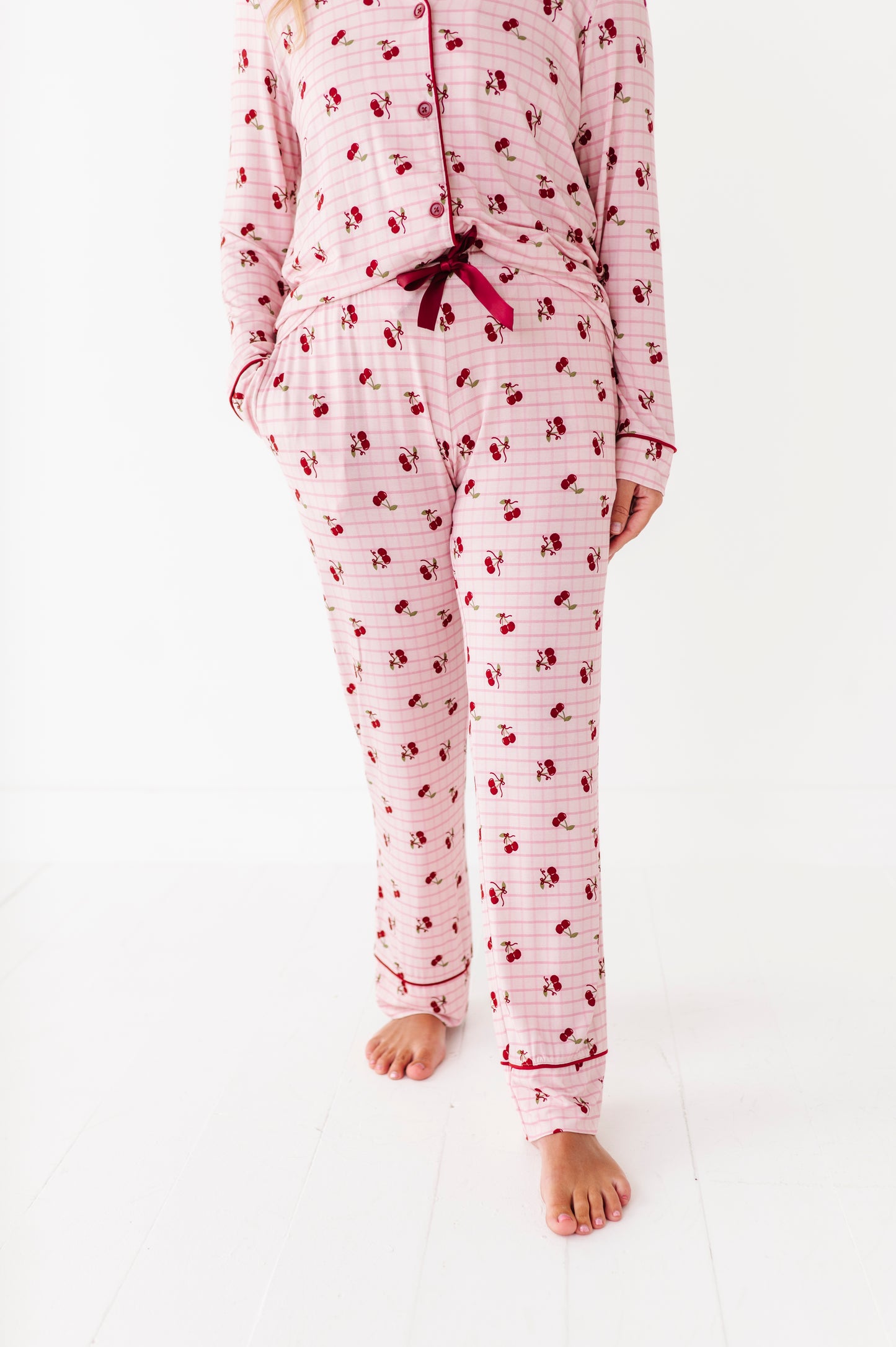 Person wearing a pink and white patterned pajama set on a white background
