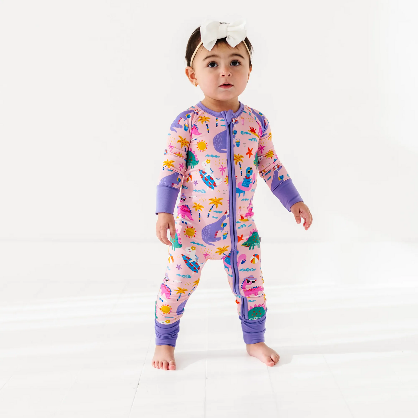 Baby Girl in dinosaur pajamas by Kiki and Lulu
