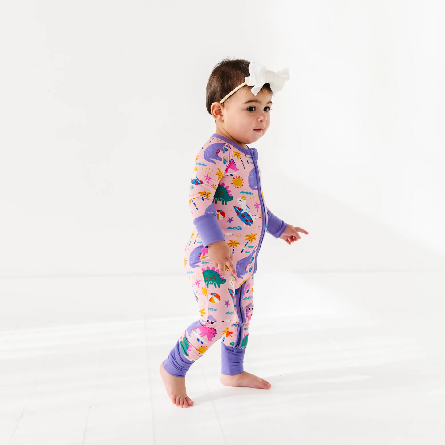 Baby Girl in dinosaur pajamas by Kiki and Lulu