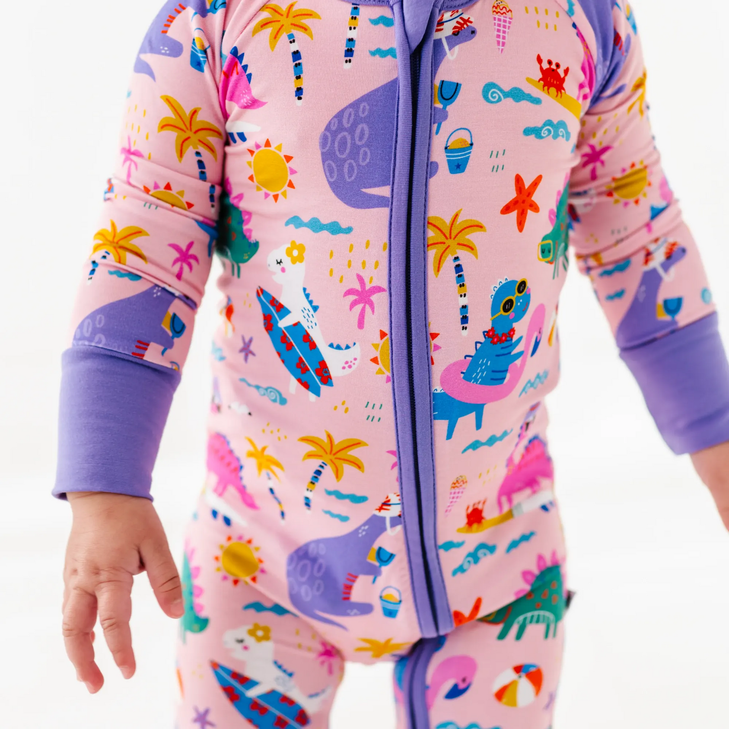 Baby Girl in dinosaur pajamas by Kiki and Lulu
