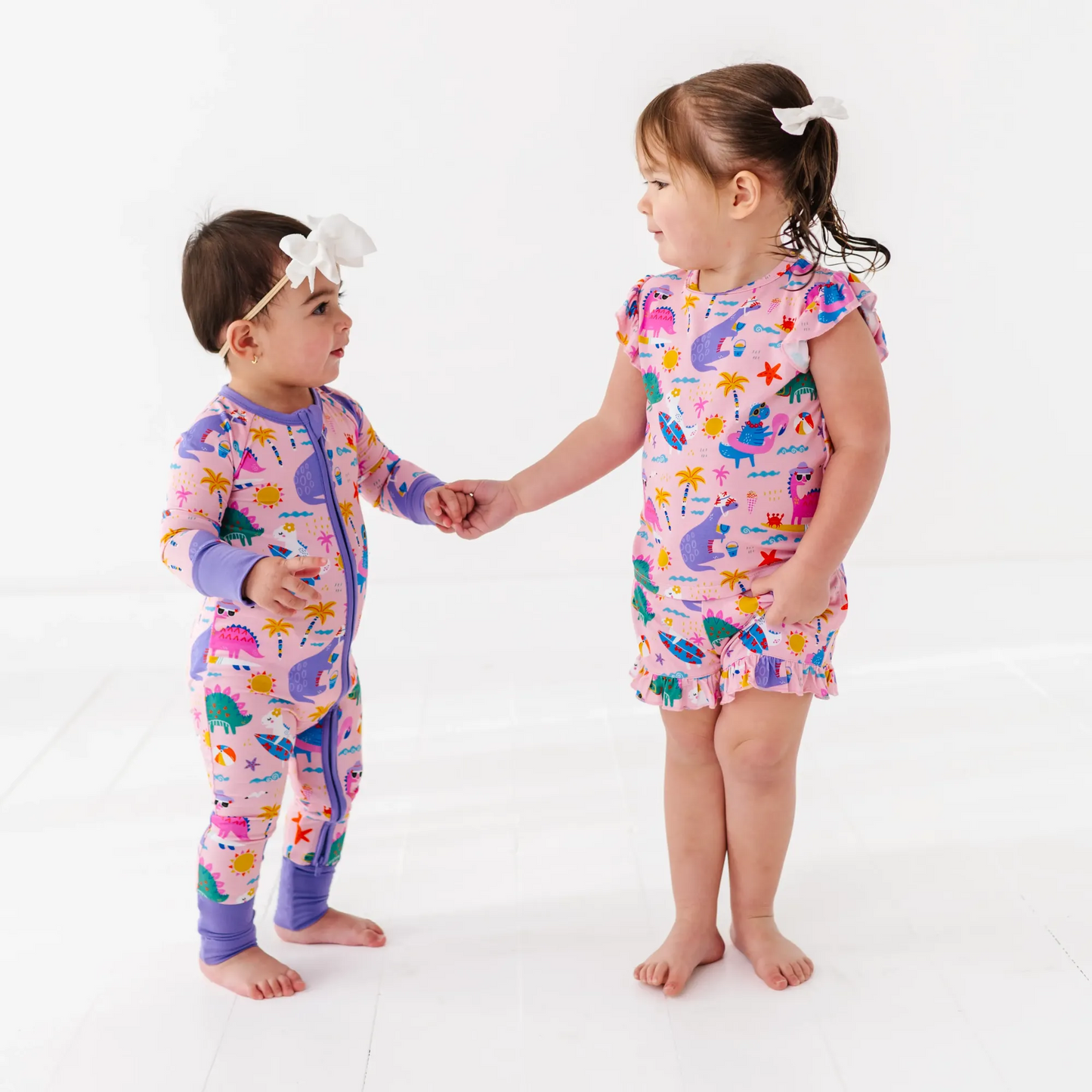 Baby Girl in dinosaur pajamas by Kiki and Lulu
