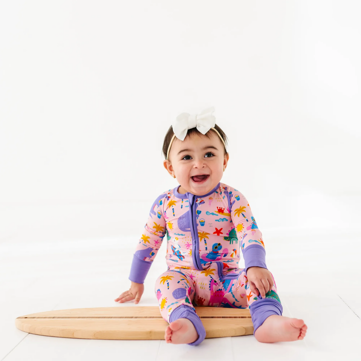 Baby Girl in dinosaur pajamas by Kiki and Lulu