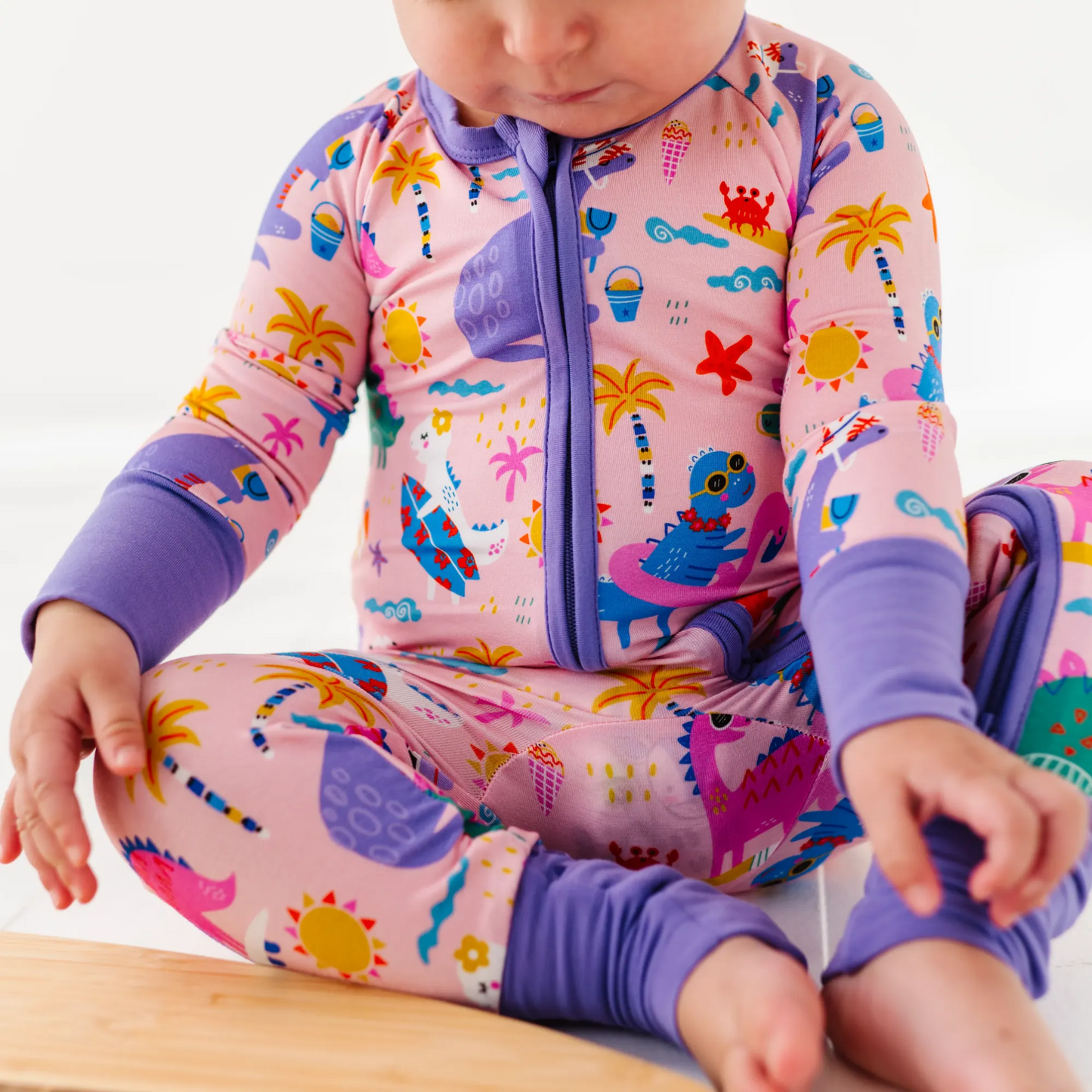 Baby Girl in dinosaur pajamas by Kiki and Lulu
