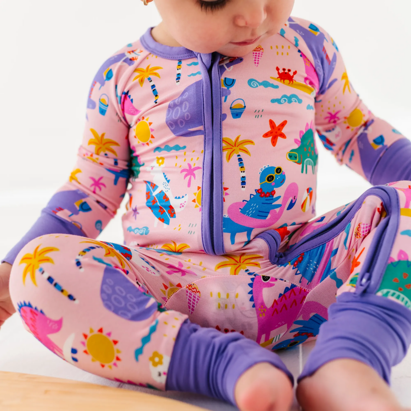 Baby Girl in dinosaur pajamas by Kiki and Lulu