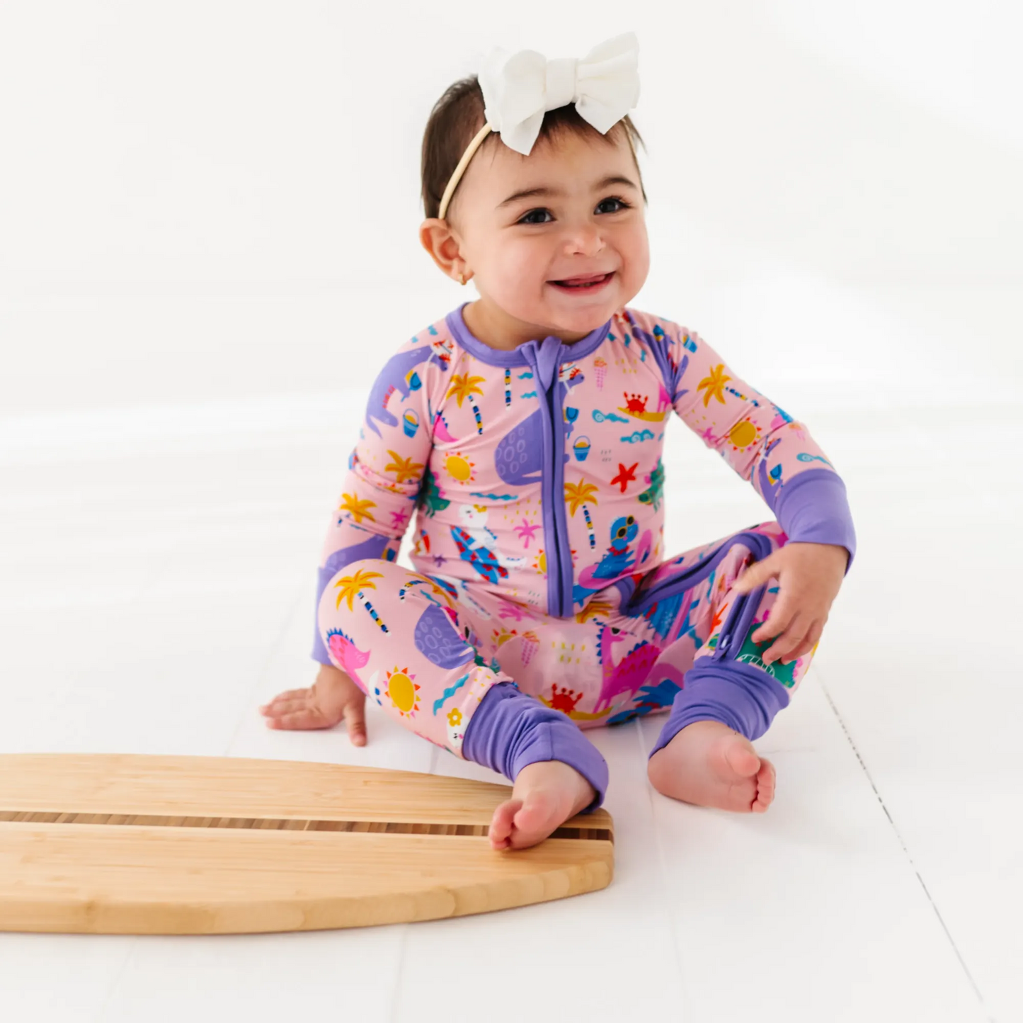 Baby Girl in dinosaur pajamas by Kiki and Lulu