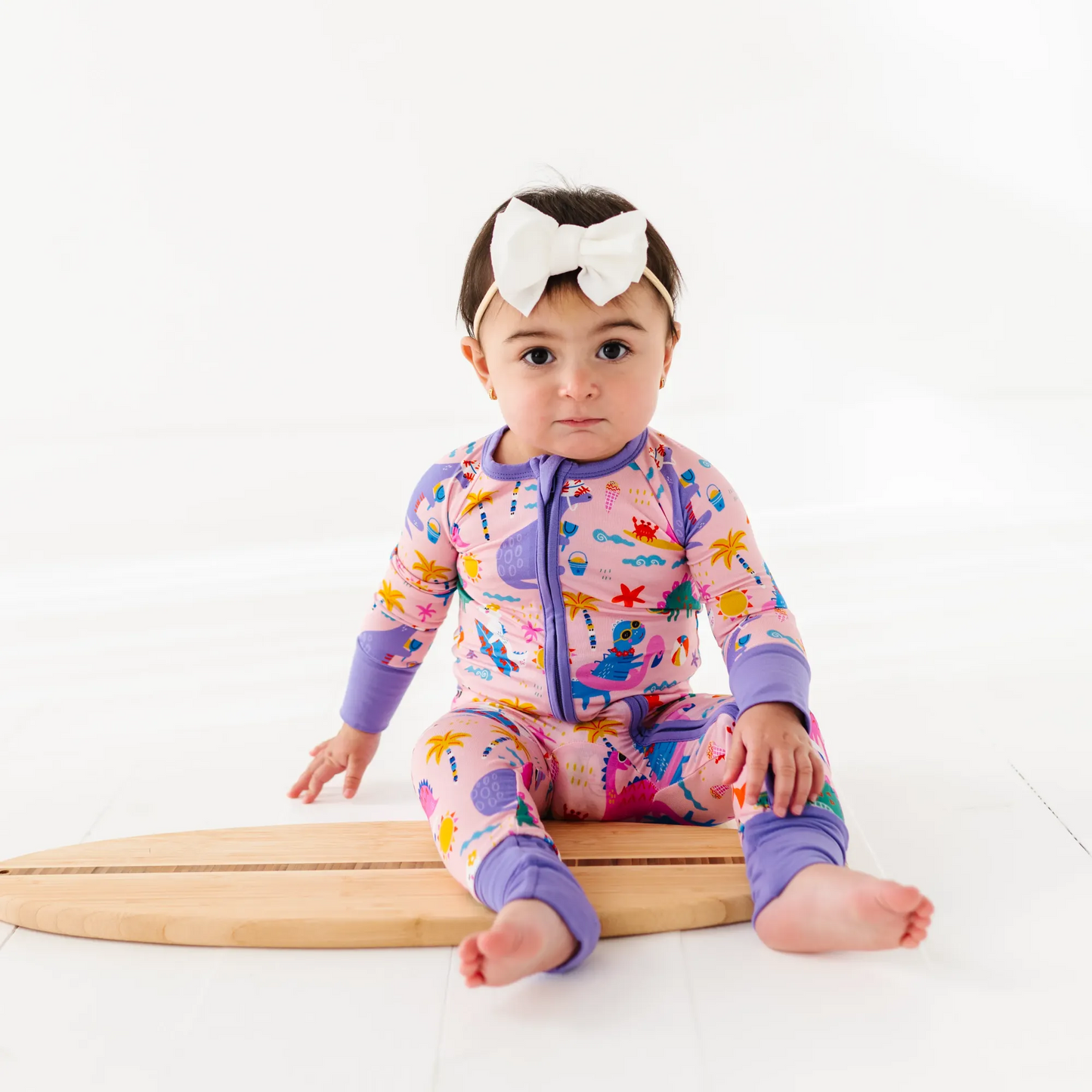 Baby Girl in dinosaur pajamas by Kiki and Lulu