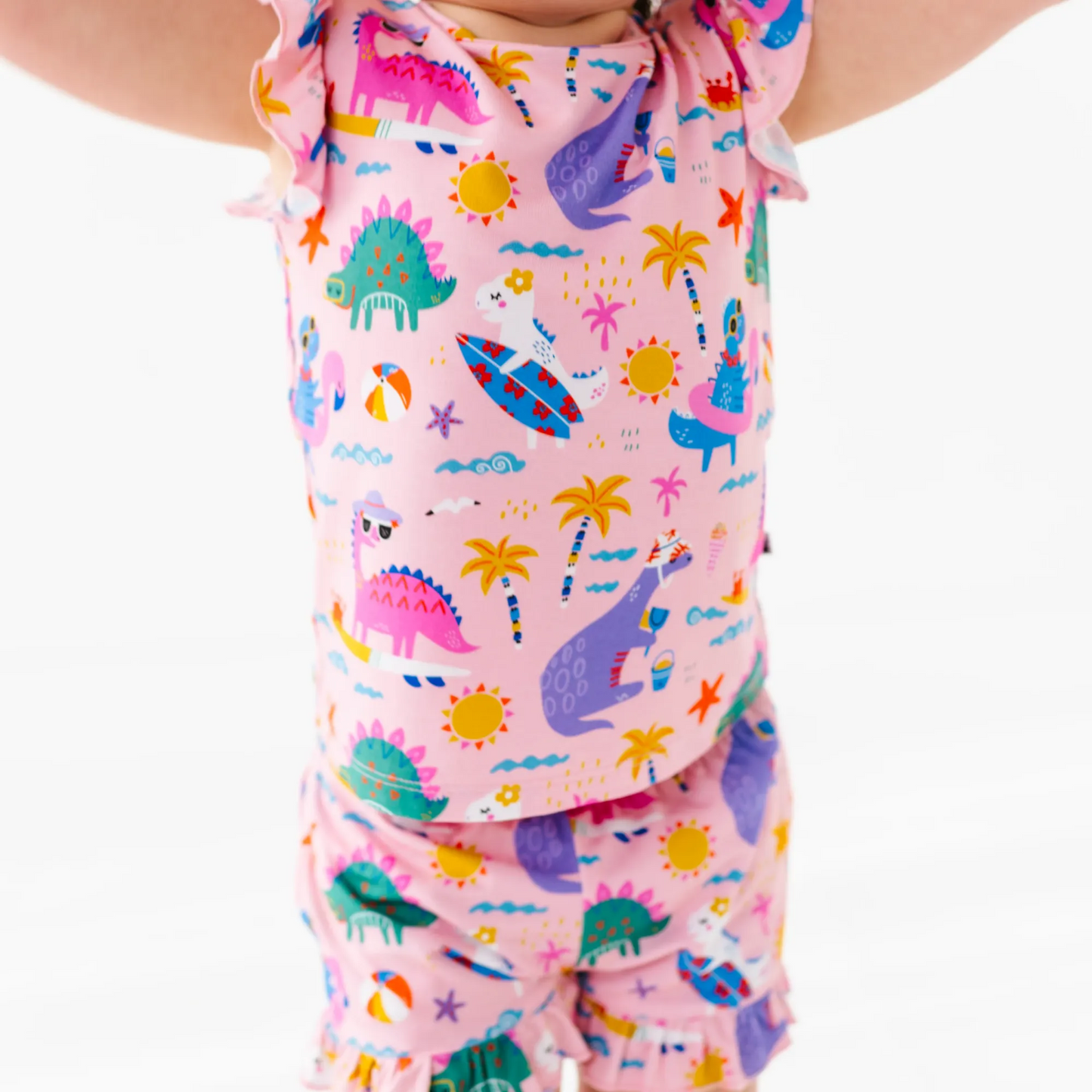 Girl in short pajama dinosaur set by Kiki and Lulu