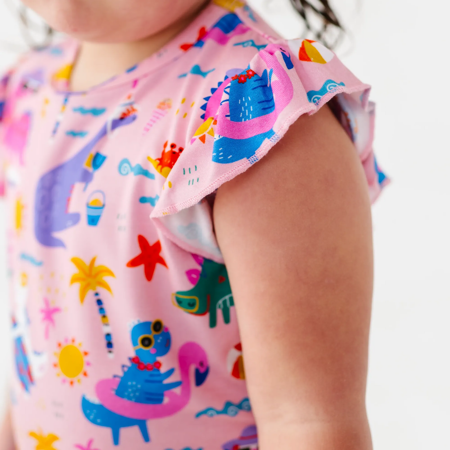 Girl in short pajama dinosaur set by Kiki and Lulu
