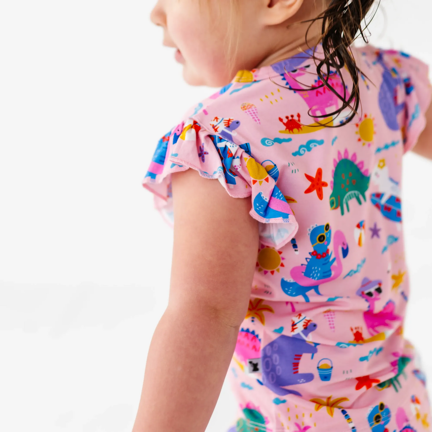 Girl in short pajama dinosaur set by Kiki and Lulu