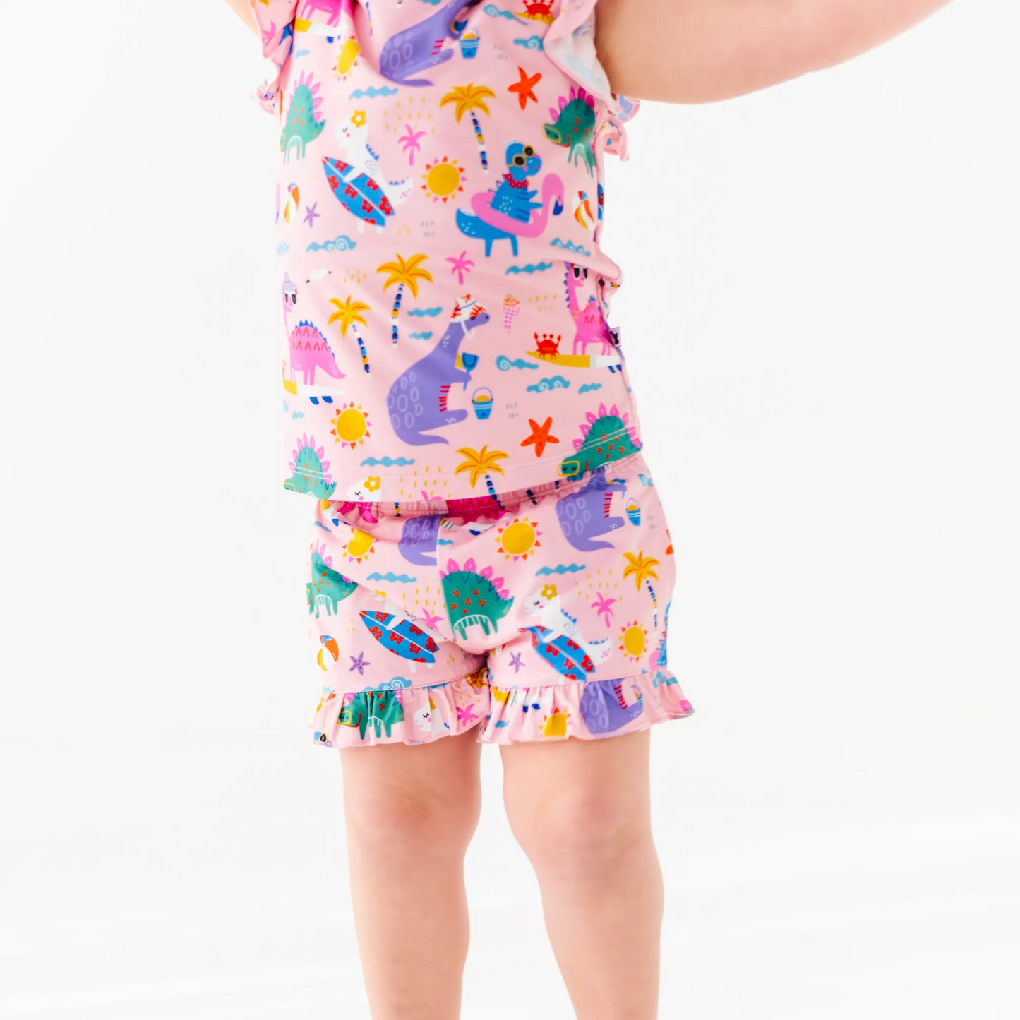 Girl in short pajama dinosaur set by Kiki and Lulu