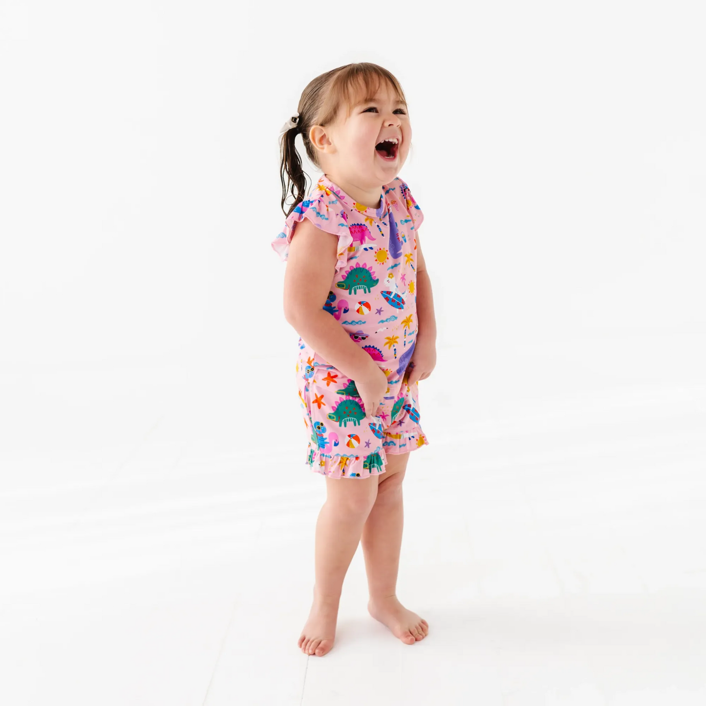 Girl in short pajama dinosaur set by Kiki and Lulu