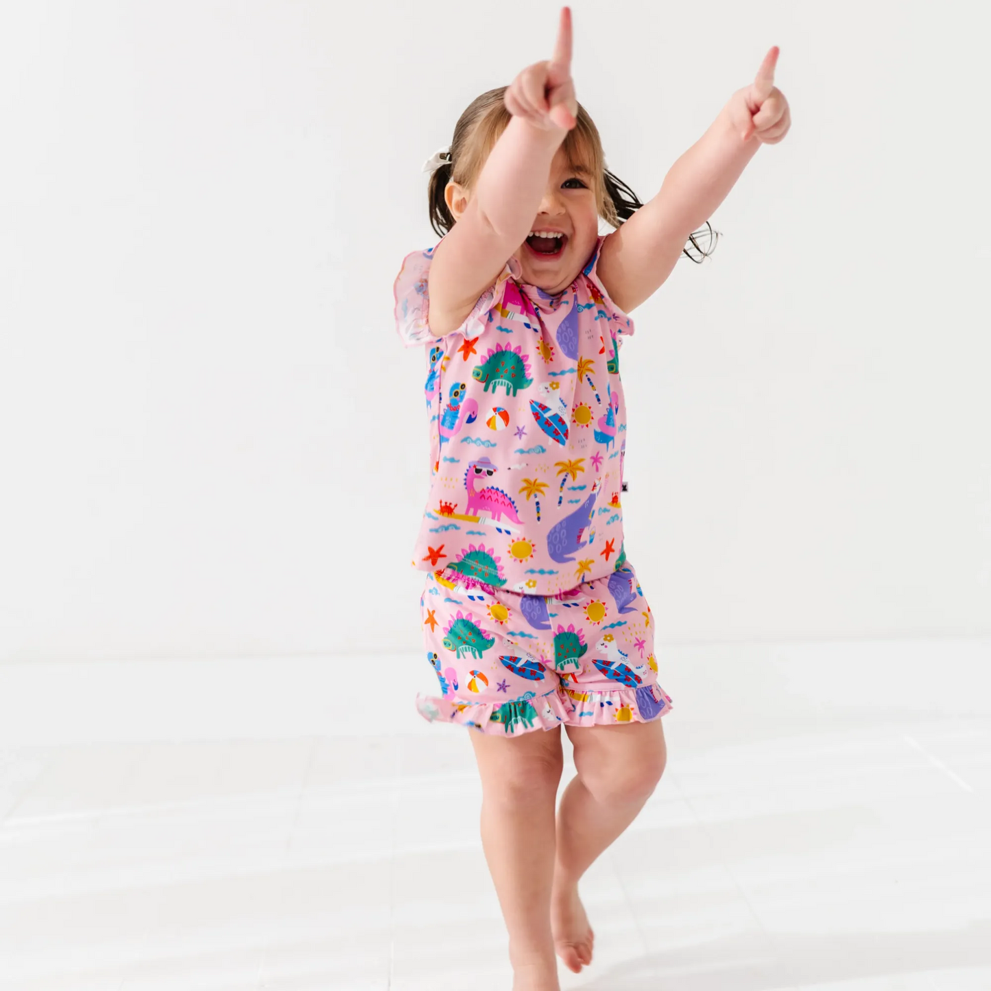 Girl in short pajama dinosaur set by Kiki and Lulu