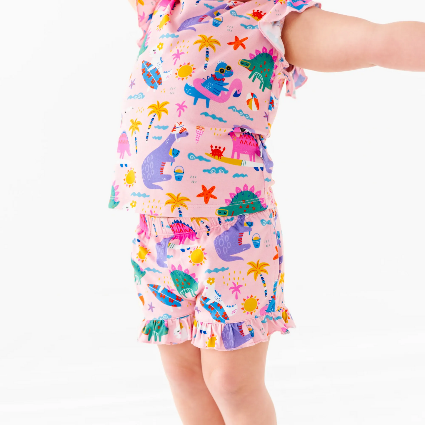 Girl in short pajama dinosaur set by Kiki and Lulu