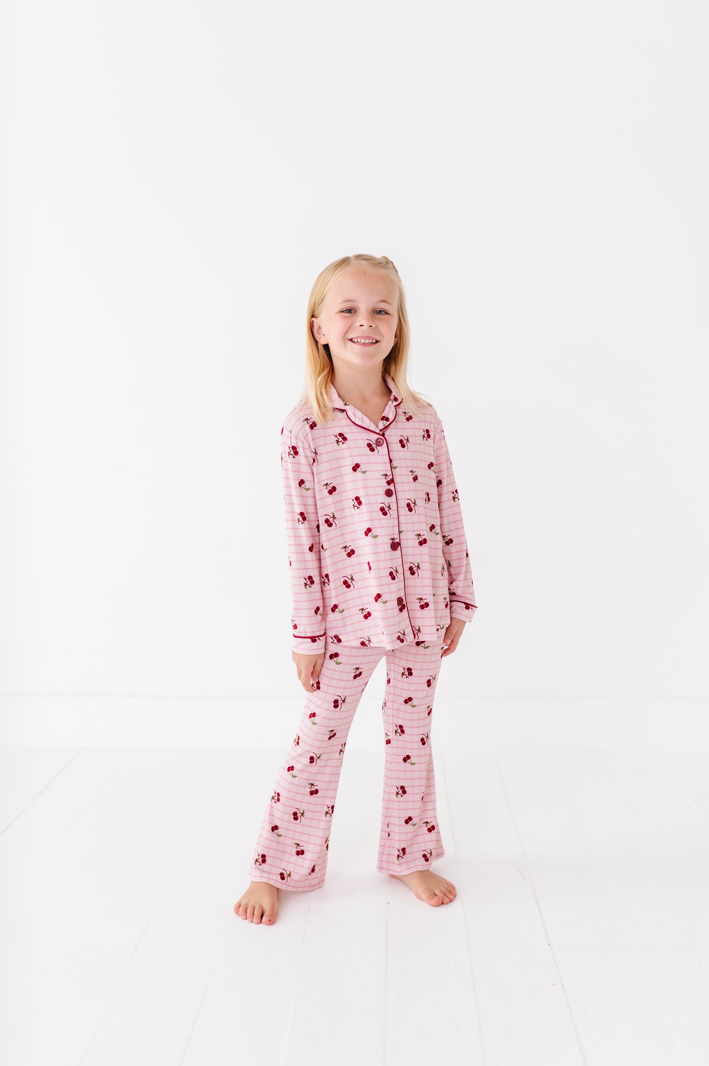 Young girl wearing pink pajamas with a pattern on a white background