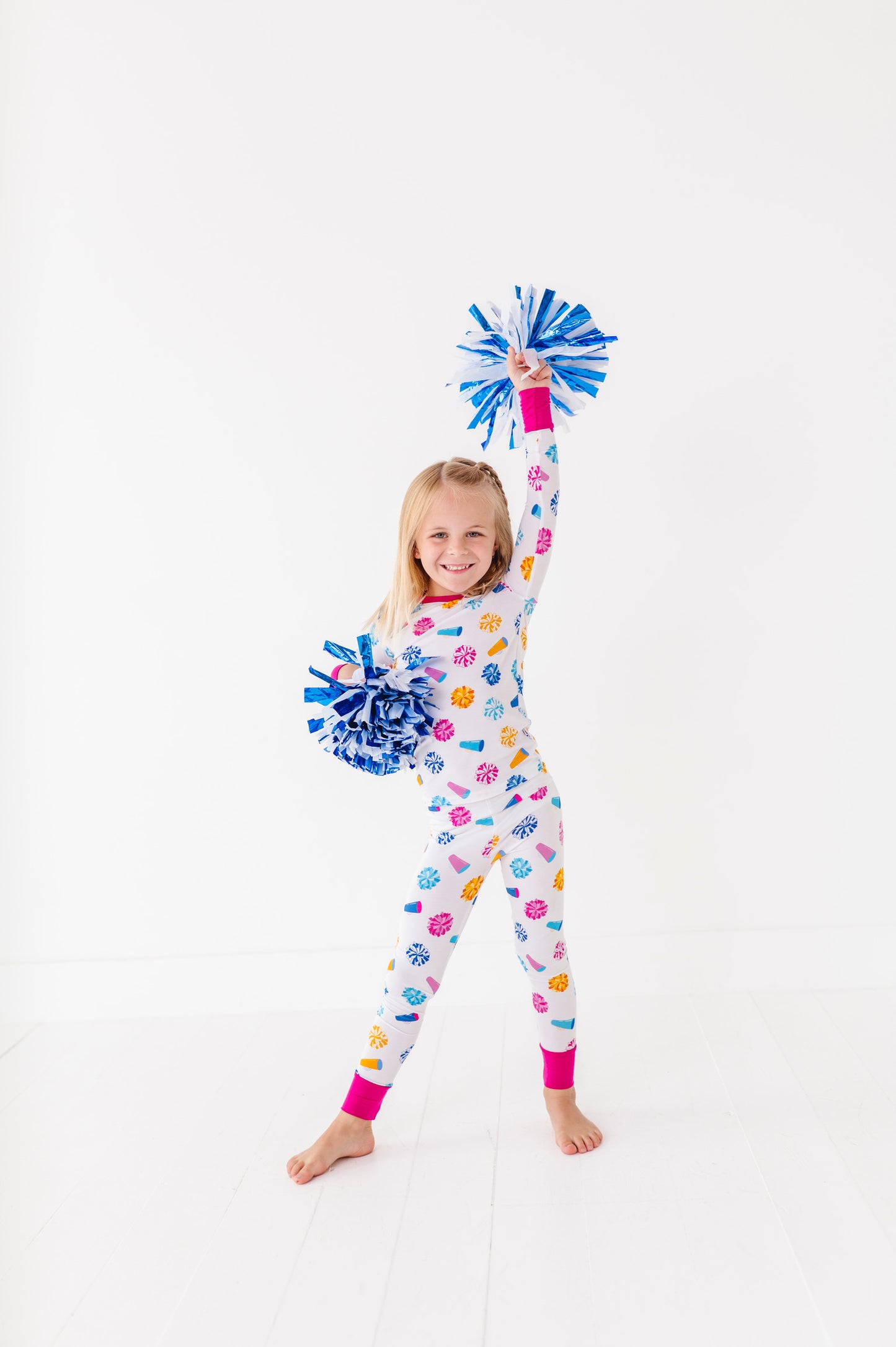 Child wearing a colorful pajamaa with pom-poms on a white background