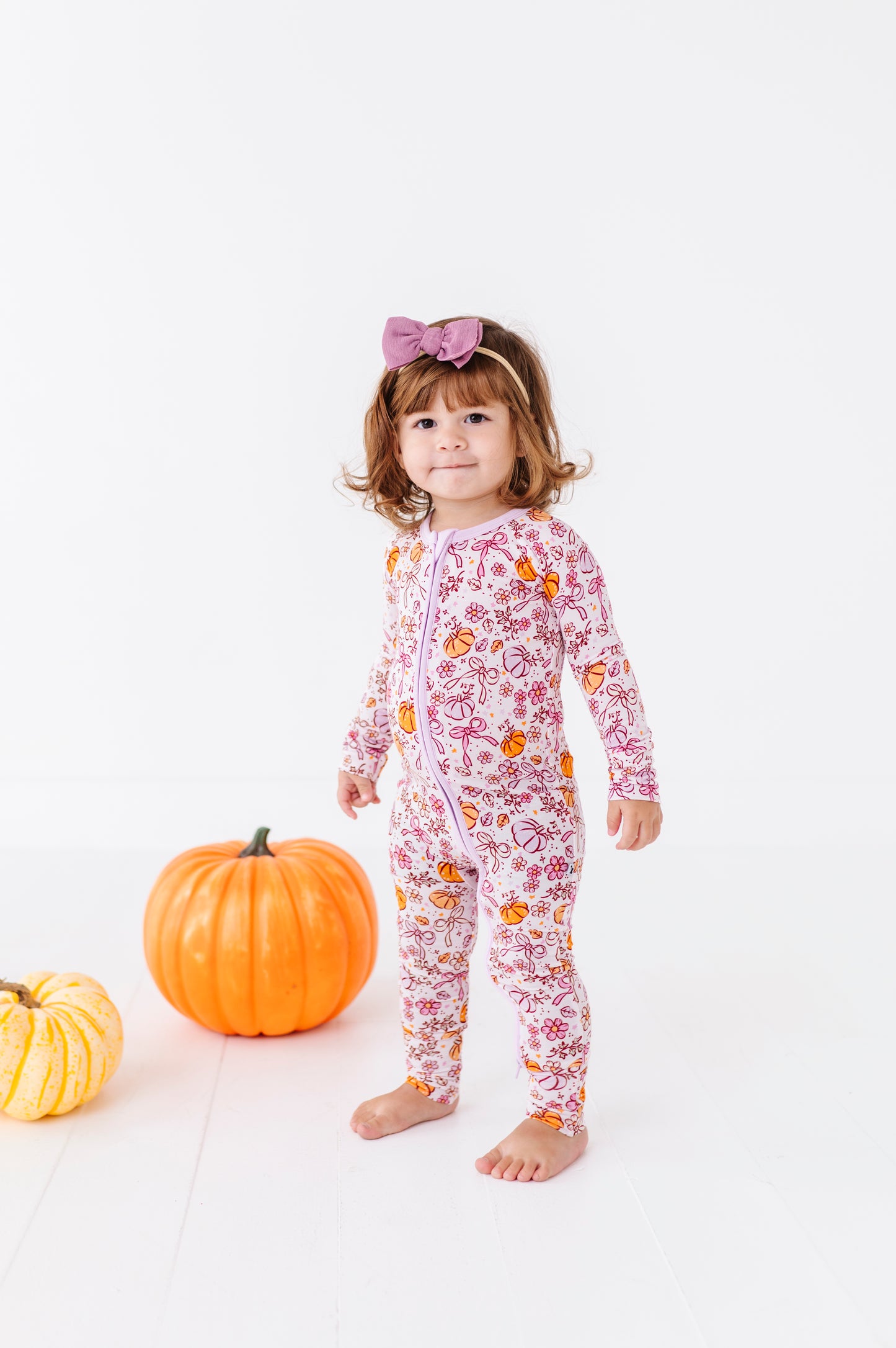 Girl in Purple Pumpkin and Bow Footies