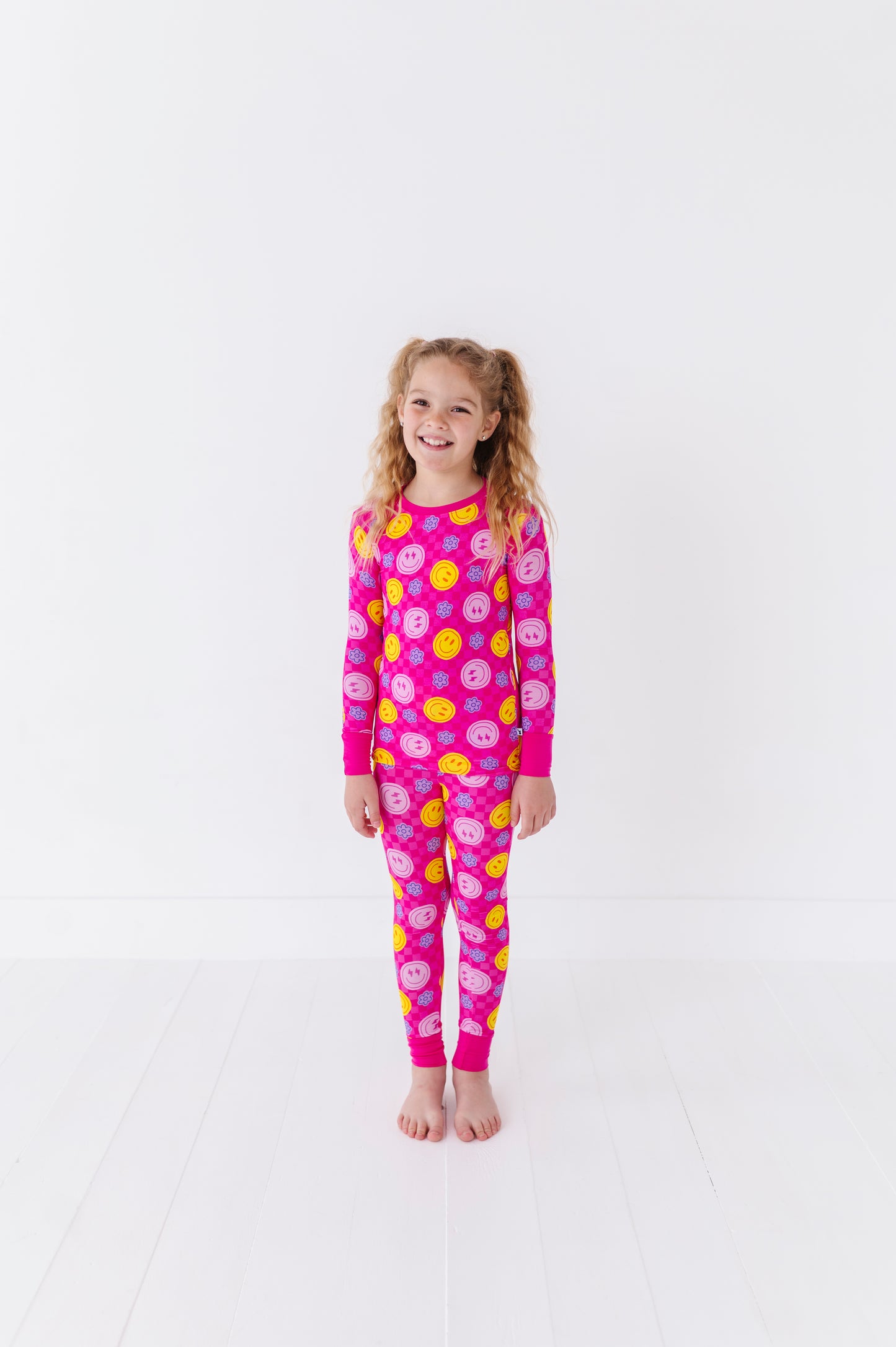 Girl wearing neon smiley pajamas By Kiki Lulu