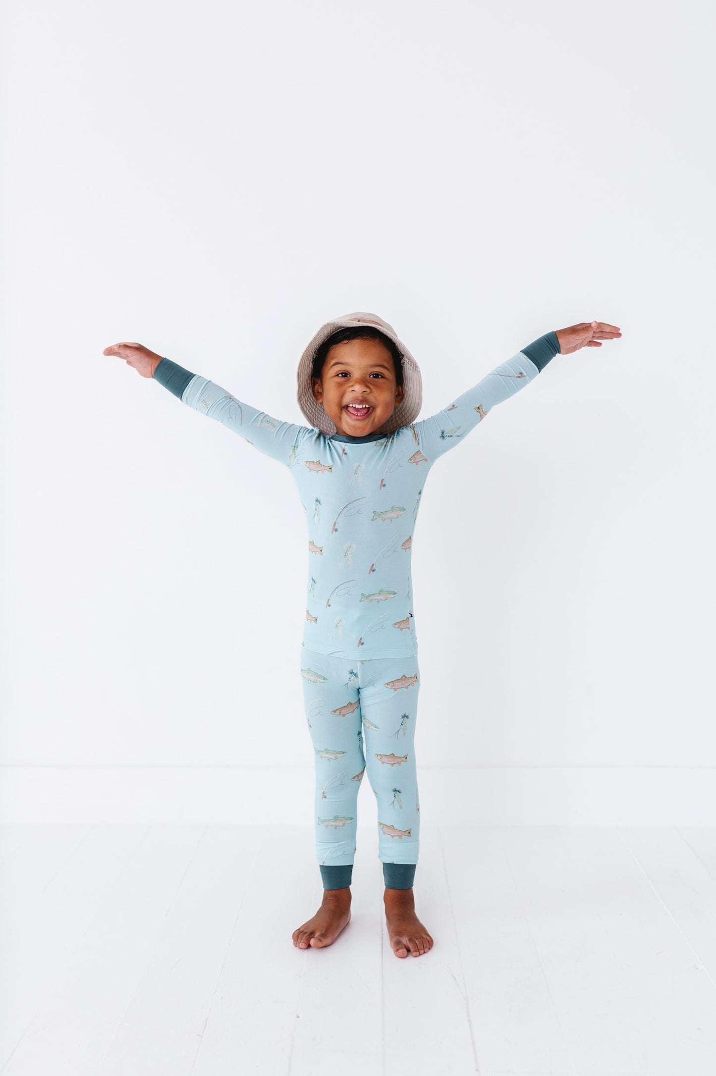 Child wearing a light blue onesie with animal prints on a white background