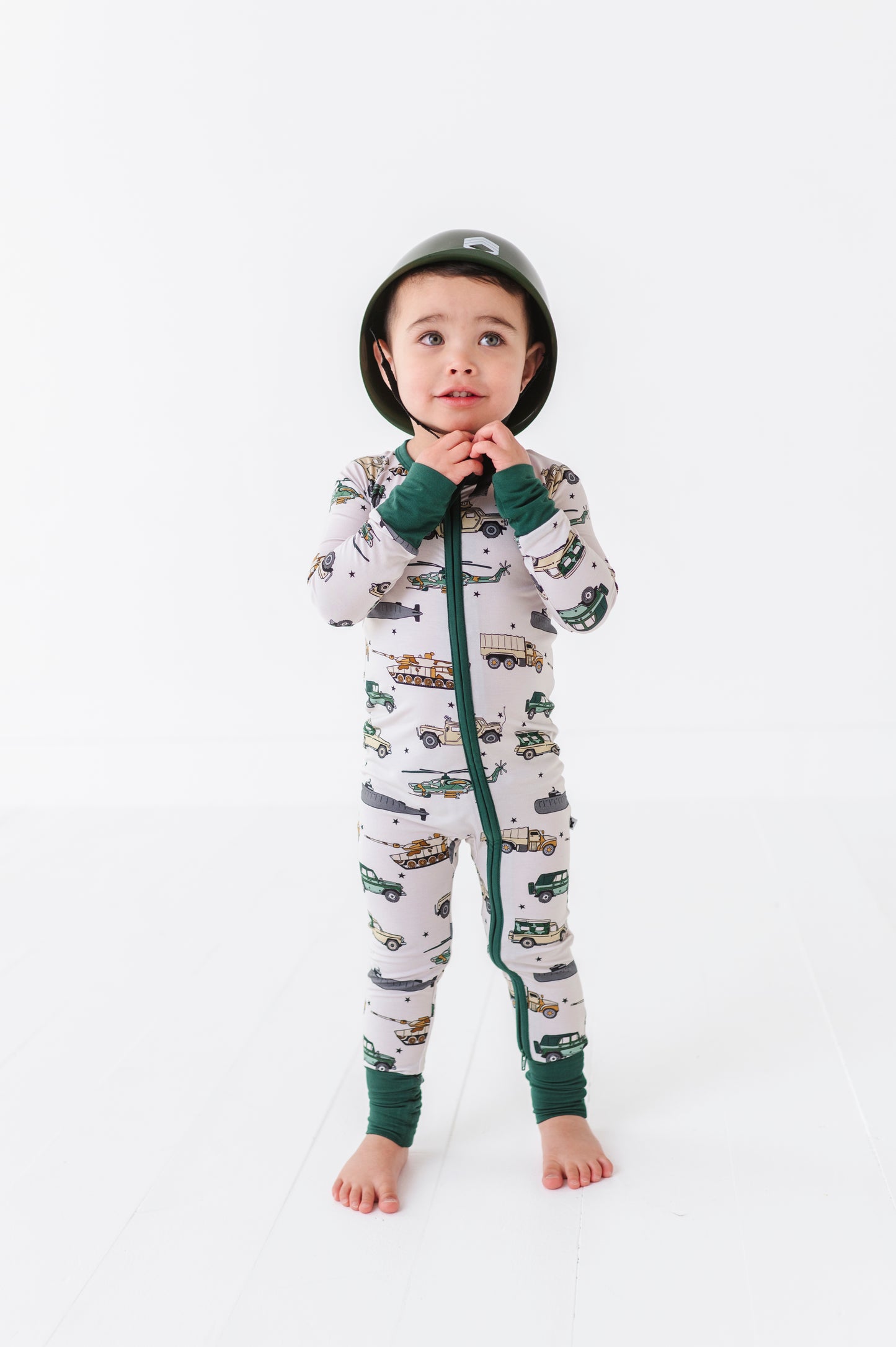 Boy rocking Military Vehicle Zip Pajamas