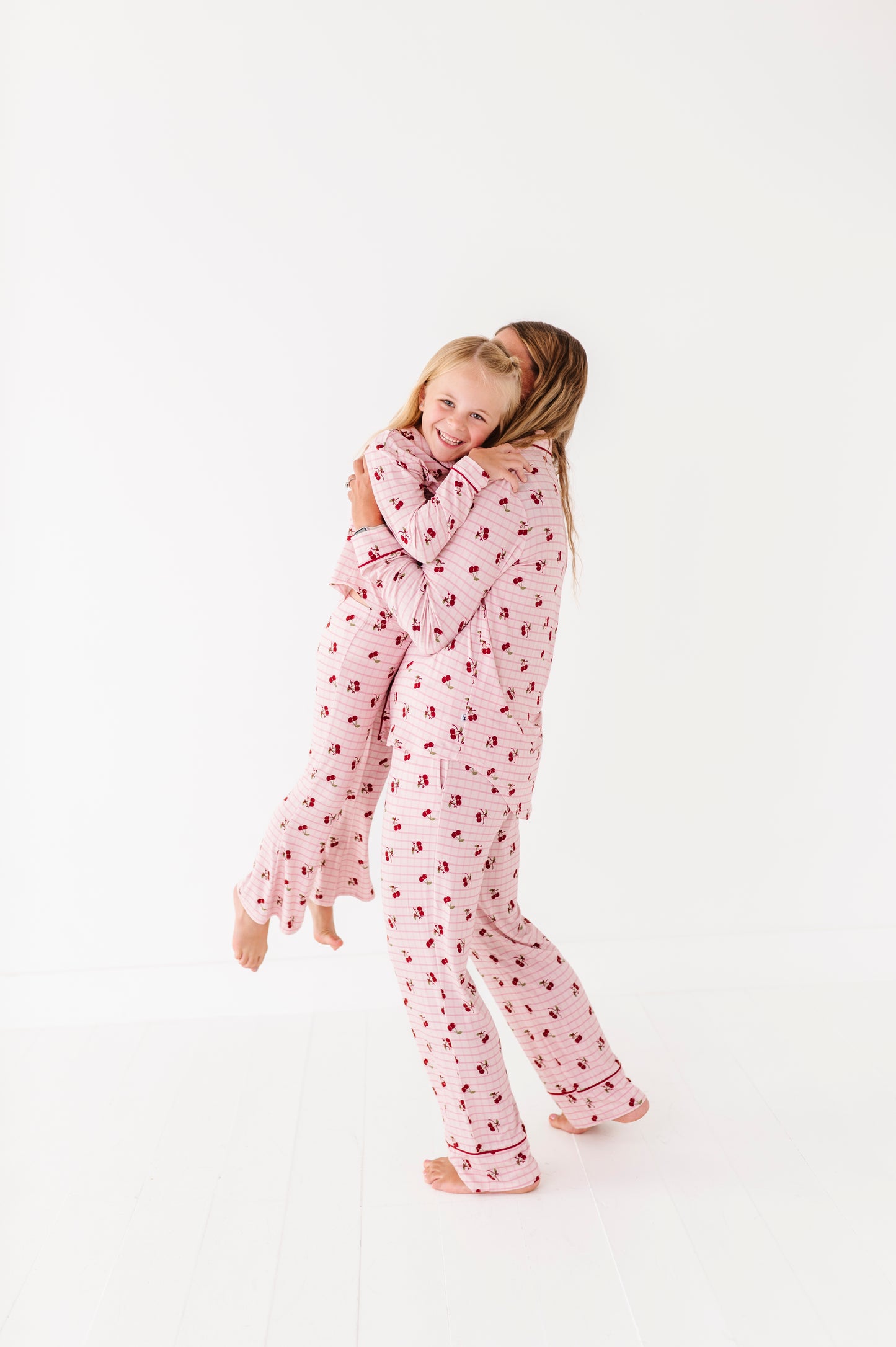Child wearing pink pajamas with a heart pattern on a white background