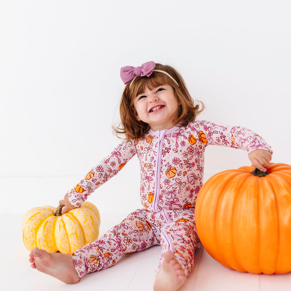 
                      
                        Girl in Purple Pumpkin and Bow Footies by Kiki and Lulu
                      
                    