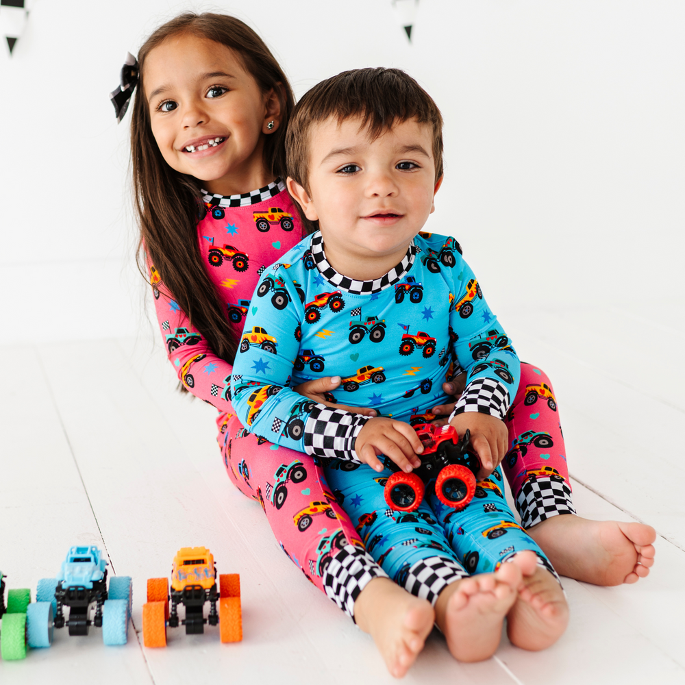 
                      
                        Brother and sister in sibling matching monster truck pajamas by Kiki and Lulu
                      
                    