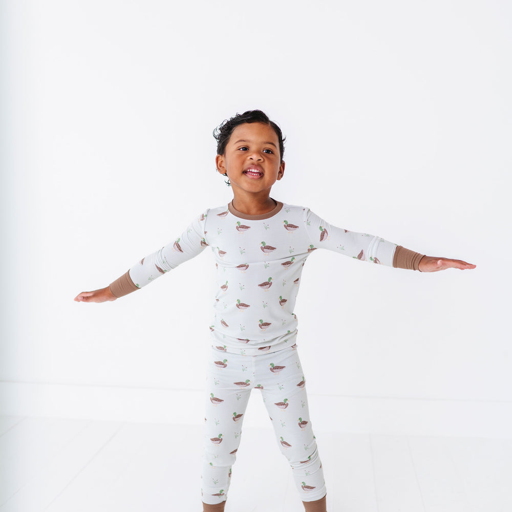 
                      
                        Child wearing a white long-sleeve pajama set with small patterns on a white background
                      
                    