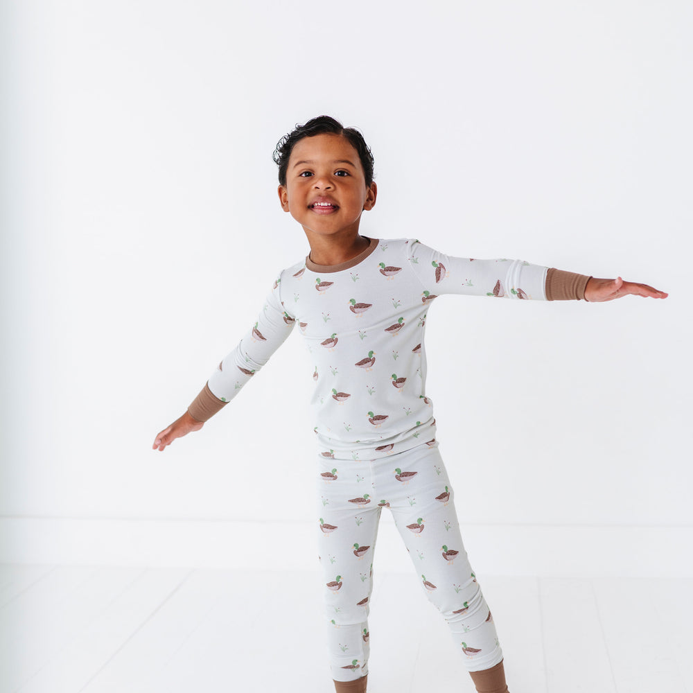 
                      
                        Child wearing a long-sleeve pajama set with animal pattern on a white background
                      
                    