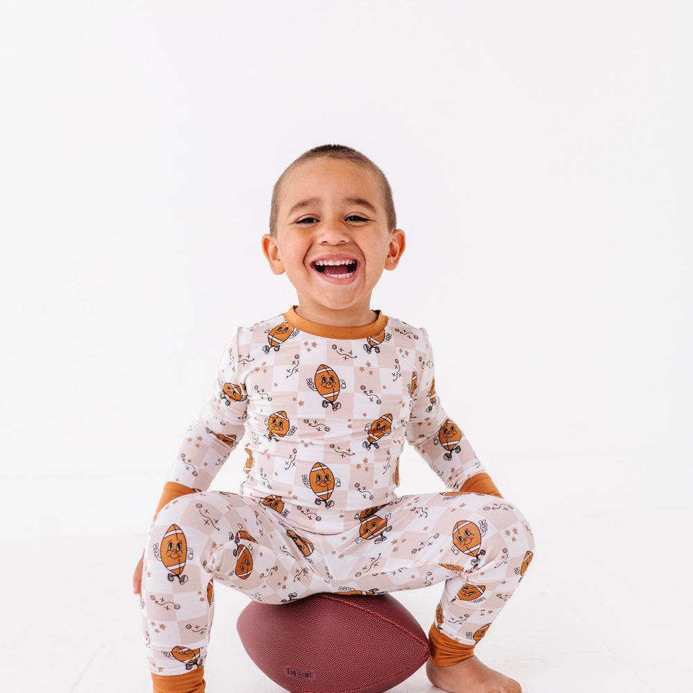 
                      
                        Child wearing a patterned outfit sitting on a ball against a white background
                      
                    