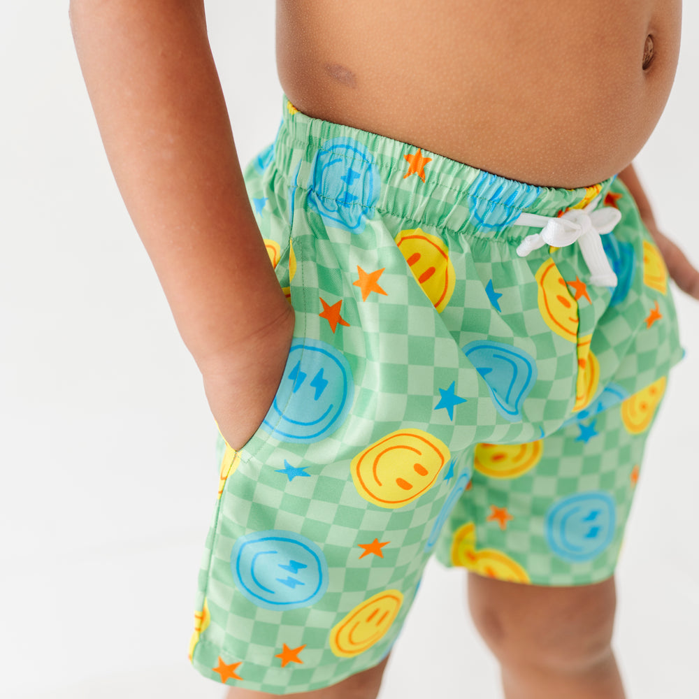 Boy in Neon Smiley Swim Trunks