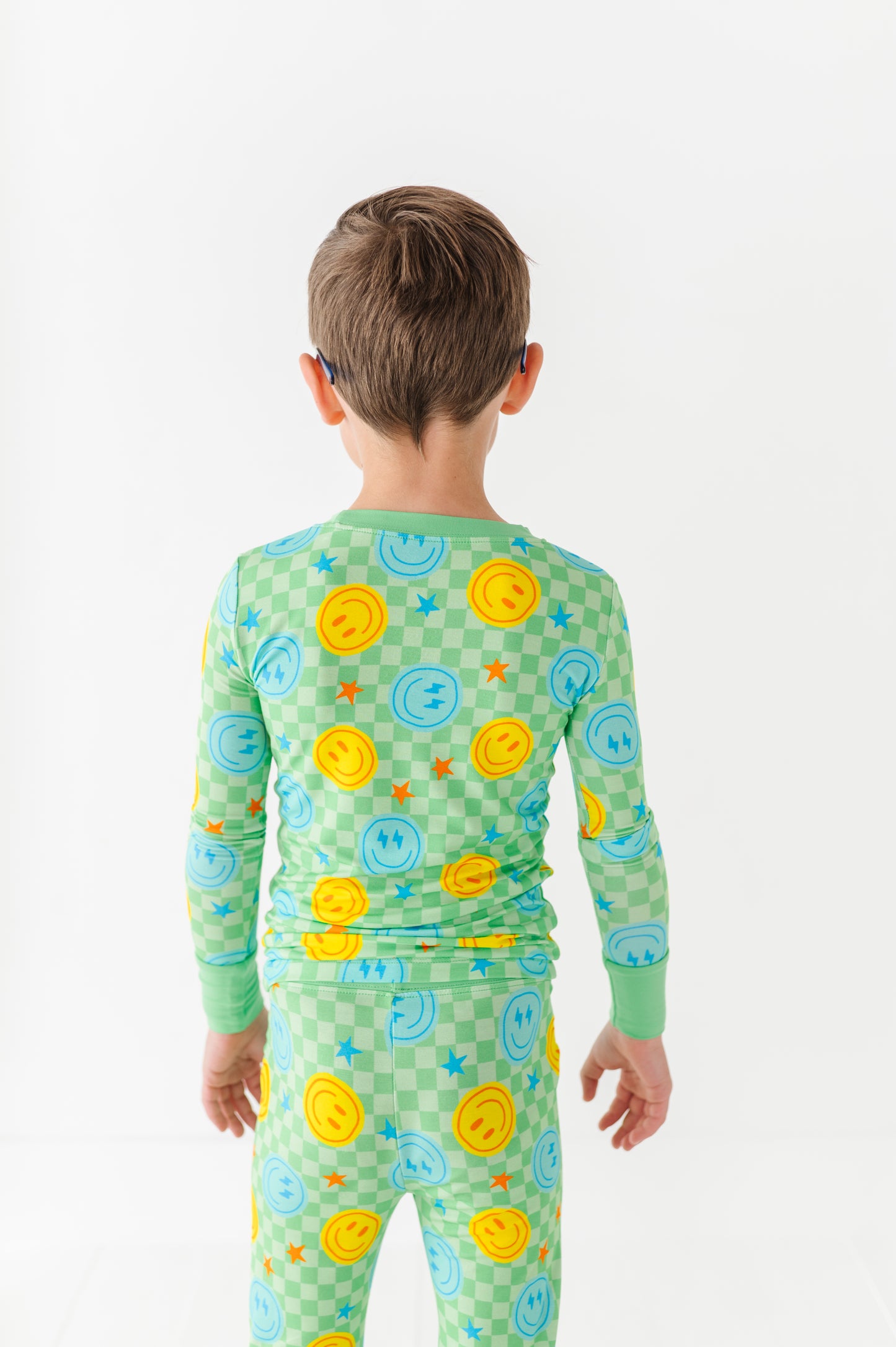 Boy wearing neon smiley pajamasby Kiki Lulu