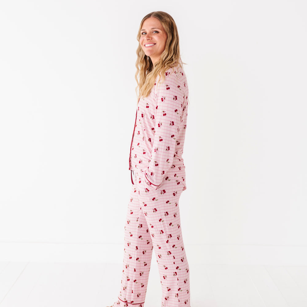
                      
                        Woman wearing pink pajamas with a cherry pattern on a white background
                      
                    