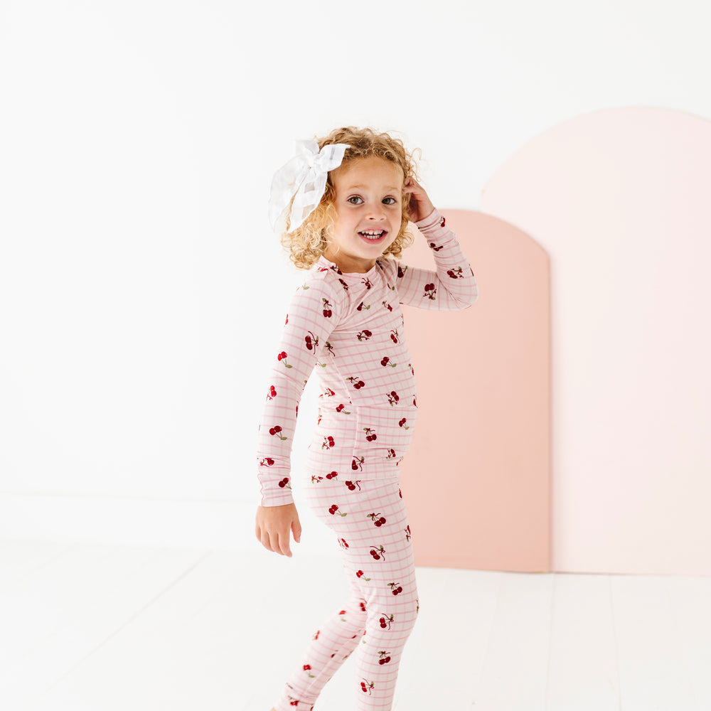 
                      
                        Child wearing a cherry-patterned onesie on a white background
                      
                    