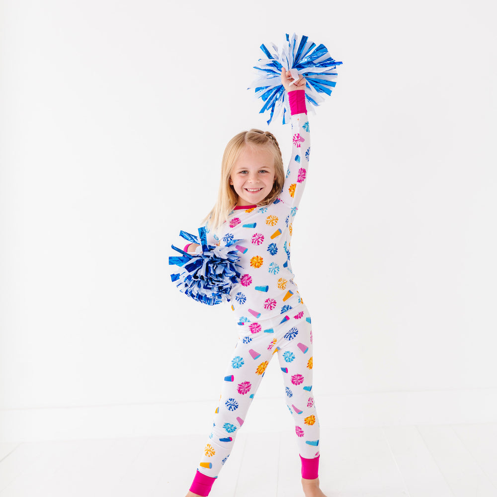 
                      
                        Child wearing a colorful pajamaa with pom-poms on a white background
                      
                    