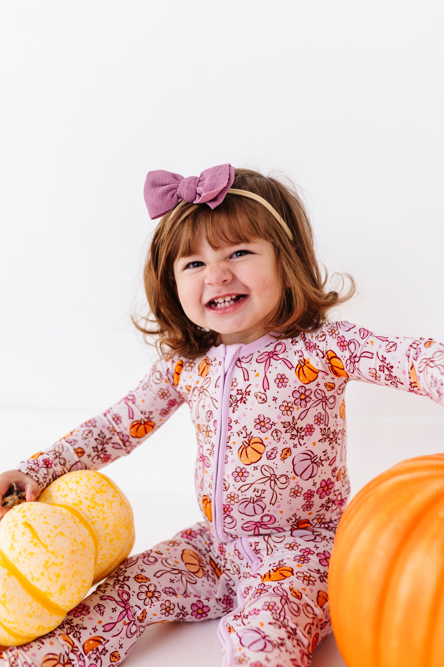 Girl in Purple Pumpkin and Bow Footies by Kiki and Lulu