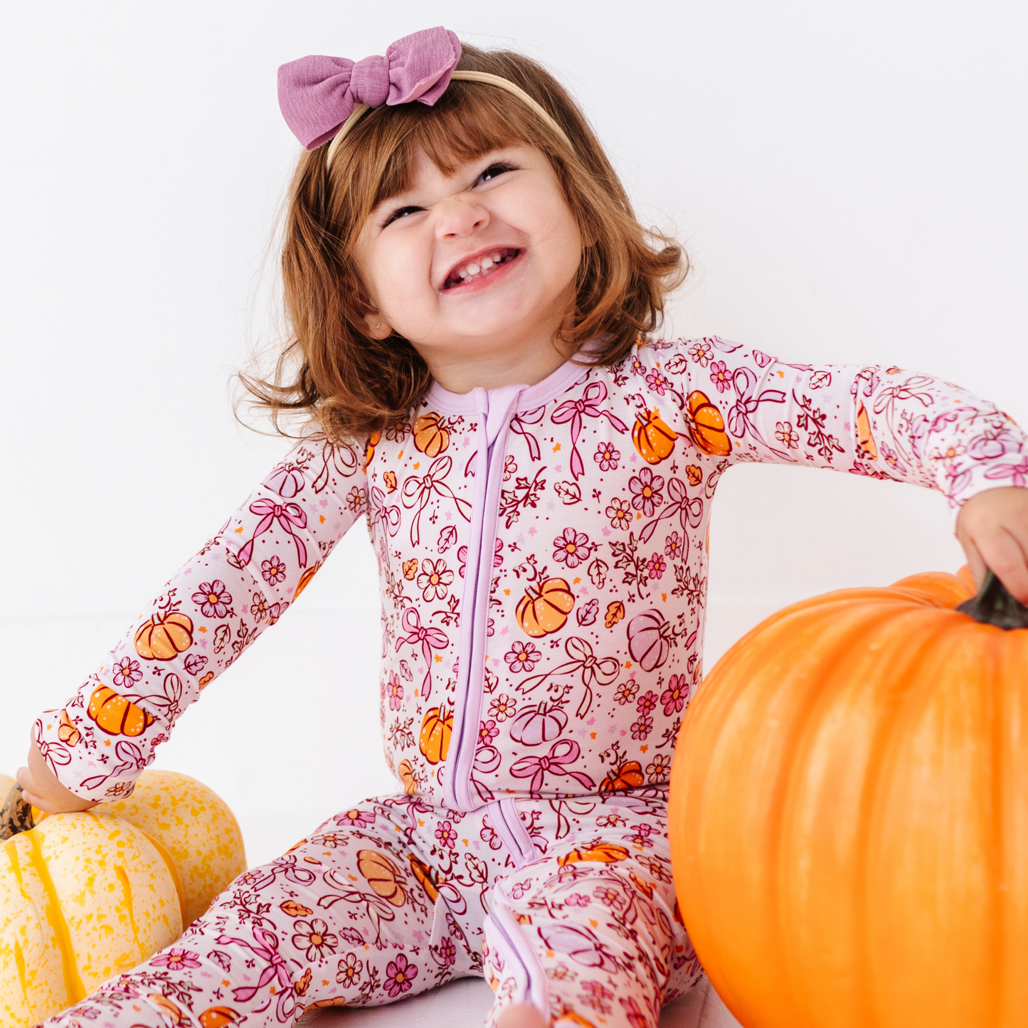 Girl in Purple Pumpkin and Bow Pajamas