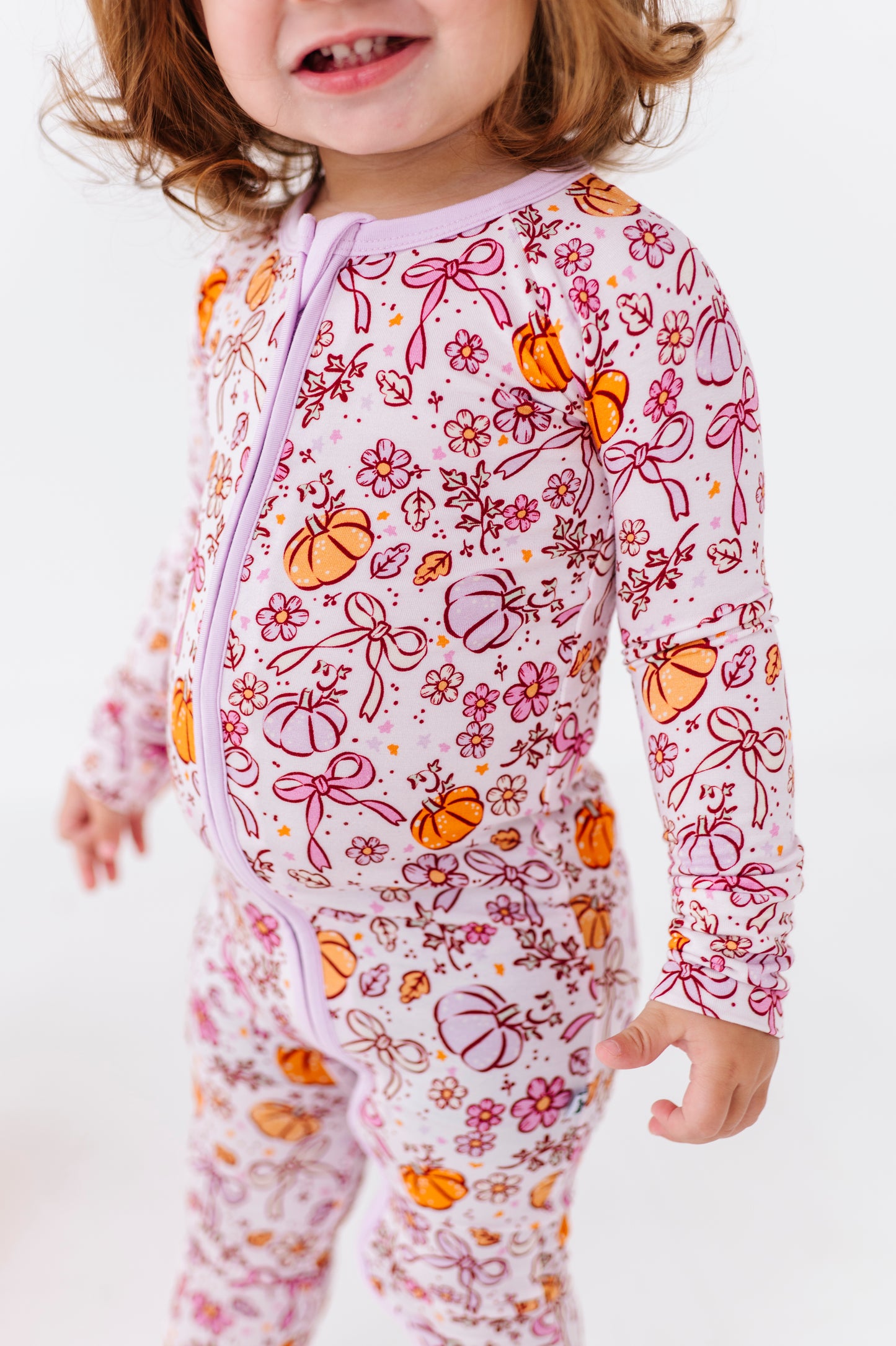 Girl in Purple Pumpkin and Bow Pajamas