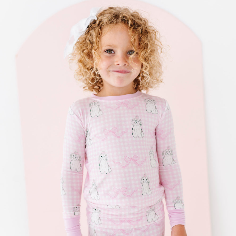 
                      
                        Child wearing pink pajamas with animal pattern on a white background
                      
                    