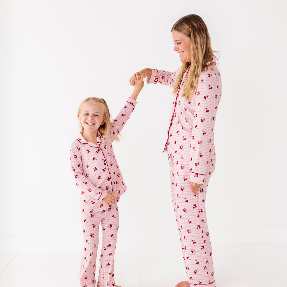 
                      
                        Mother and daughter wearing matching pink pajamas with a heart pattern on a white background
                      
                    