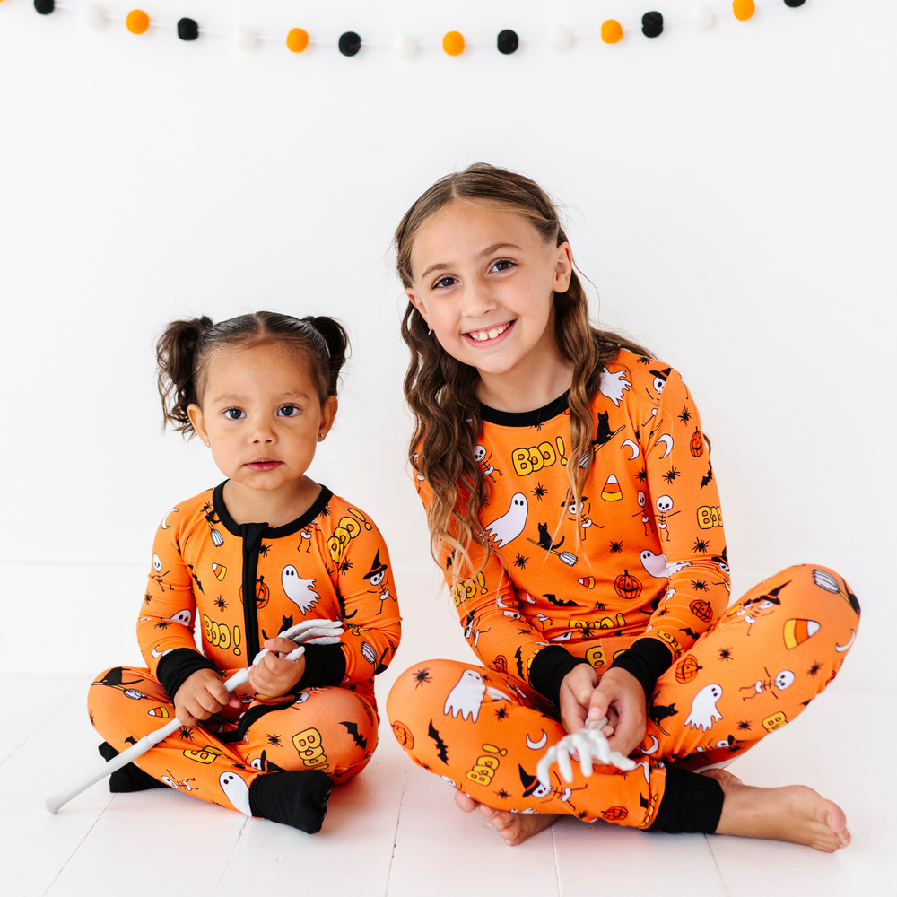 
                      
                        Girl in orange Sibling Matching Halloween pajamas by Kiki and Lulu
                      
                    