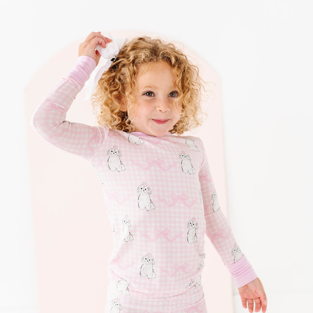 
                      
                        Child wearing pink pajamas with animal prints on a white background
                      
                    
